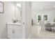 Bathroom with white vanity, marble counter, modern fixtures, and a view into dining area at 11312 Fox Hill Dr, Charlotte, NC 28269