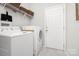 Laundry room with white washer, dryer, shelving for storage, and a door to outside at 11312 Fox Hill Dr, Charlotte, NC 28269