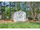 Outdoor storage shed in a well-maintained backyard with lush landscaping and mature trees at 11312 Fox Hill Dr, Charlotte, NC 28269