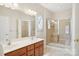 Well-lit bathroom featuring double sinks, vanity, large mirrors, and tiled walk-in shower at 117 Pine Lake Dr, Monroe, NC 28110