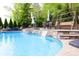 The backyard pool features a stone waterfall, lush landscaping, and plenty of seating at 1215 39Th Ne Ave, Hickory, NC 28601