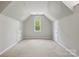 Finished attic space featuring an arched window, carpeting, and separate storage spaces at 1305 Foxfield Rd # 60, Waxhaw, NC 28173