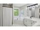 Neutral bathroom with a combined tub and shower, single sink vanity, and a frosted window at 1305 Foxfield Rd # 60, Waxhaw, NC 28173