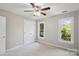 A well-lit bedroom featuring a ceiling fan, neutral walls, and two windows offering tree views at 1305 Foxfield Rd # 60, Waxhaw, NC 28173
