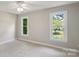 A well-lit bedroom with two windows, neutral walls, carpeted floors, and plenty of space at 1305 Foxfield Rd # 60, Waxhaw, NC 28173