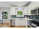 Bright kitchen featuring white cabinets, updated appliances, and a view of the lush backyard at 1305 Foxfield Rd # 60, Waxhaw, NC 28173