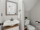 A stylish powder room featuring a pedestal sink, updated fixtures, toilet, and a framed mirror at 1305 Foxfield Rd # 60, Waxhaw, NC 28173
