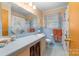 A well-lit bathroom features blue tile, floral shower curtain, and vanity with ample counter space at 1307 Armstrong Rd, Belmont, NC 28012