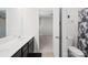Bright bathroom with double vanity and dark cabinets leading to an open doorway and a separate toilet area at 13547 Roderick Dr, Huntersville, NC 28078