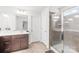 Clean, well-lit bathroom features a dark vanity, shower with glass door, and tiled flooring at 13547 Roderick Dr, Huntersville, NC 28078