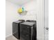Well-organized laundry room features modern, black front-load washer and dryer, and shelving for supplies at 13547 Roderick Dr, Huntersville, NC 28078