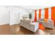 Bright living room with orange curtains, stylish sofa, hardwood floors, and a modern entertainment center at 13547 Roderick Dr, Huntersville, NC 28078