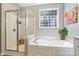 Bright bathroom featuring a soaking tub with shower and tile window at 1405 Ridge Haven Rd, Waxhaw, NC 28173