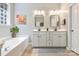 Bright bathroom featuring double vanities, a soaking tub, and modern fixtures at 1405 Ridge Haven Rd, Waxhaw, NC 28173