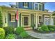 Inviting front porch with American flag, neatly landscaped yard, and rocking chairs at 1405 Ridge Haven Rd, Waxhaw, NC 28173