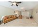 Spacious carpeted living room with ceiling fans, neutral walls, and comfortable leather furniture at 1405 Ridge Haven Rd, Waxhaw, NC 28173