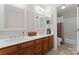 Well-lit bathroom featuring double sinks, wood cabinets and framed mirrors at 15744 Berryfield St, Huntersville, NC 28078
