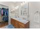 Well-lit bathroom featuring double sinks with marble countertops, wood cabinets, and a separate shower room at 15744 Berryfield St, Huntersville, NC 28078