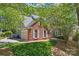 Charming brick home with a well-maintained lawn, attached garage, and lush trees providing shade and privacy at 15744 Berryfield St, Huntersville, NC 28078