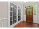 Elegant foyer featuring wood floors, a decorative front door with glass, and glass french doors for a grand entrance at 15744 Berryfield St, Huntersville, NC 28078