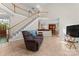 Open-concept living room with a staircase, sofa, and tile flooring, seamlessly connecting to the dining area and kitchen at 15744 Berryfield St, Huntersville, NC 28078