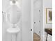 Clean bathroom featuring a modern pedestal sink, a large oval mirror, and clean white walls at 2129 Tom Sadler Rd # 7160, Charlotte, NC 28214