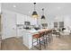 Open kitchen with island seating, stainless appliances, white cabinets, and hardwood flooring throughout at 2129 Tom Sadler Rd # 7160, Charlotte, NC 28214