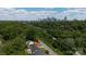 Aerial view showcasing a home nestled among lush greenery with the city skyline in the distance at 2138 Revolution Park Dr, Charlotte, NC 28208