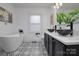 Elegant bathroom featuring a freestanding tub, marble countertops, and designer black and white patterned floors at 2138 Revolution Park Dr, Charlotte, NC 28208