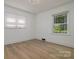 Bright bedroom with wood floors and natural light streaming through the double windows overlooking the yard at 2138 Revolution Park Dr, Charlotte, NC 28208