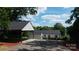 Rear view showcasing the carport and house, featuring neutral siding, a dark roof, and ample parking space at 2138 Revolution Park Dr, Charlotte, NC 28208