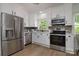 Well-lit kitchen featuring stainless steel appliances, white cabinetry, and modern countertops at 2138 Revolution Park Dr, Charlotte, NC 28208