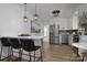 A modern kitchen with stainless steel appliances, white cabinets, a breakfast bar, and pendant lighting at 2138 Revolution Park Dr, Charlotte, NC 28208