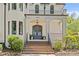Elegant home entrance with brick steps leading to a covered porch and sophisticated gray double doors at 2200 Hastings Dr, Charlotte, NC 28207