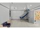 Bright, neutral game room with basketball hoop, built-in storage, and climbing wall in adjacent room at 2200 Hastings Dr, Charlotte, NC 28207