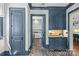 Hallway features herringbone floors, blue trim, blue cabinetry, and view into the laundry room at 2200 Hastings Dr, Charlotte, NC 28207