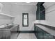 Well-lit laundry room features modern washer, ample counter space, and dark teal cabinets at 2200 Hastings Dr, Charlotte, NC 28207