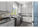 Laundry room with stainless washer and dryer, cabinetry, and herringbone floors at 2200 Hastings Dr, Charlotte, NC 28207