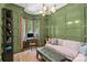 Stylish green study featuring a comfortable sofa, traditional desk, and eye-catching chandelier at 2200 Hastings Dr, Charlotte, NC 28207