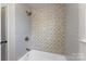 Bathroom shower area featuring decorative tile at 2232 Glenraven Ave, Gastonia, NC 28052