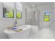 Bright white bathroom featuring a soaking tub, glass-enclosed shower, and double vanity at 2316 Westminster Pl, Charlotte, NC 28207