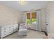 Bedroom with neutral wallpaper, white furniture, and natural light from large windows at 2316 Westminster Pl, Charlotte, NC 28207