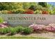 Neighborhood sign for Westminster Park, surrounded by vibrant flowering bushes and lush greenery at 2316 Westminster Pl, Charlotte, NC 28207