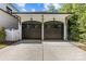 Two-car garage with stylish wood doors, decorative sconces, and wood accents on the white brick exterior at 2316 Westminster Pl, Charlotte, NC 28207