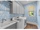 Well-organized laundry room featuring a sink, washer, dryer, cabinets, and stylish wallpaper at 2316 Westminster Pl, Charlotte, NC 28207