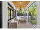 Serene screened-in patio with wood ceiling, ceiling fan, and stylish wicker furniture for outdoor relaxation at 2316 Westminster Pl, Charlotte, NC 28207