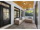 Inviting covered patio with stone flooring, ceiling fan, and comfortable wicker seating arrangement at 2316 Westminster Pl, Charlotte, NC 28207