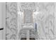 Chic powder room with pedestal sink, elegant mirror, and beautiful palm-patterned wallpaper at 2316 Westminster Pl, Charlotte, NC 28207