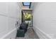 Narrow side yard with gravel path between white brick walls, featuring a grill and access to the backyard at 2316 Westminster Pl, Charlotte, NC 28207