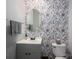 Stylish half bathroom with floral wallpaper, round mirror, and gray vanity at 2388 Loch Stone Dr # E, Gastonia, NC 28054